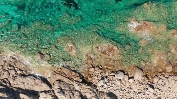 Vista aérea superior da rocha branca, praia rochosa, ondas esmagando na praia. Mar colorido, azul-turquesa. Verão, mar, limpo e transparente — Vídeo de Stock