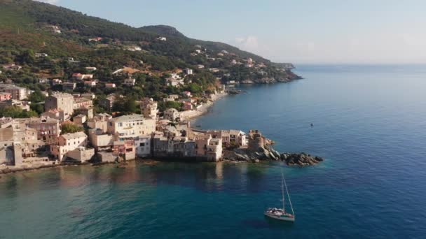 Korsika 'daki karakteristik taş köy limanının havadan görünüşü. Canlı mavi deniz. Kıyı manzarası, güzel deniz, evler, ağaçlar güneşli bir yaz gününde.. — Stok video