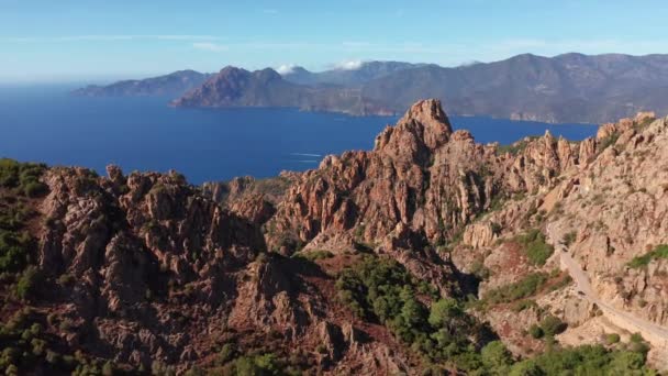 Panoramisch uitzicht op de rotsachtige rode berg, canyon met zee op de achtergrond in een zomerse zonnige dag. Karakteristieke rotsbergen, blauwe zee, blauwe lucht, zonnige dag.Corsica Calanques. — Stockvideo