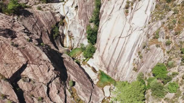 Vista aérea de la cascada pequeña, piscina natural, árboles en la roca blanca. Punto de vista del dron de la cascada característica en Córcega. Personas aventuradas y entrenadas que caminan durante el día soleado del verano — Vídeos de Stock