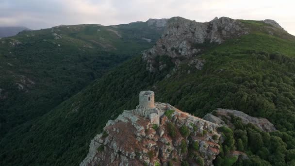 Vista aérea do monumento velho no topo da montanha. Cordilheira no fundo, floresta verde, nuvens, rochas. — Vídeo de Stock