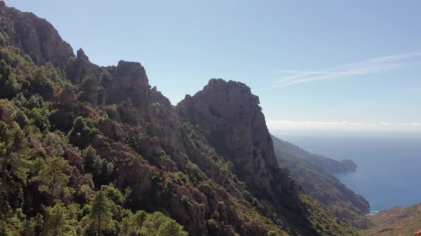 Panoramisch uitzicht op de rotsachtige rode berg, canyon met zee op de achtergrond in een zomerse zonnige dag. Karakteristieke rotsbergen, blauwe zee, blauwe lucht, zonnige dag.Corsica Calanques. — Stockvideo