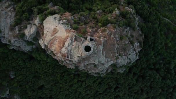 Aerial view of crumbling abandoned stone tower on the top of mountain. Top view of old ancient rocky building, green forest on mountains feet, — стоковое видео