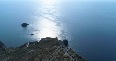 Salina kıyı şeridinin muhteşem hava manzarası. Güzel denizin önünde küçük bir köy olan iç kısımlarda. Kenarda, tepenin üstünde deniz feneri. Mavi gökyüzü, güneşli gün.