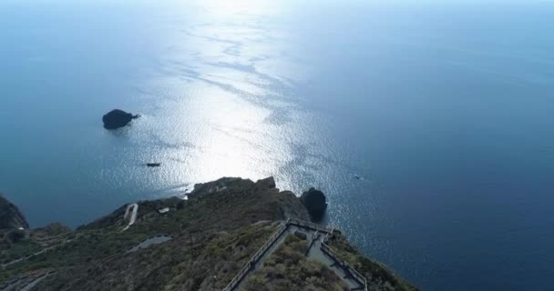 Spettacolare vista aerea della costa di Salina. L'entroterra con piccolo villaggio di fronte al bellissimo mare. di lato, faro in cima alla collina. Cielo blu, giornata di sole. — Video Stock
