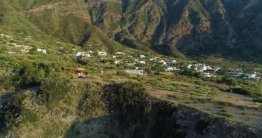Gün batımında yeşil tarlalar, ağaçlar ve küçük köylerle panoramik ve pitoresk kayalık kıyı şeridi. Bir yaz yolculuğunda Sicilya kıyılarının havadan görünüşü.