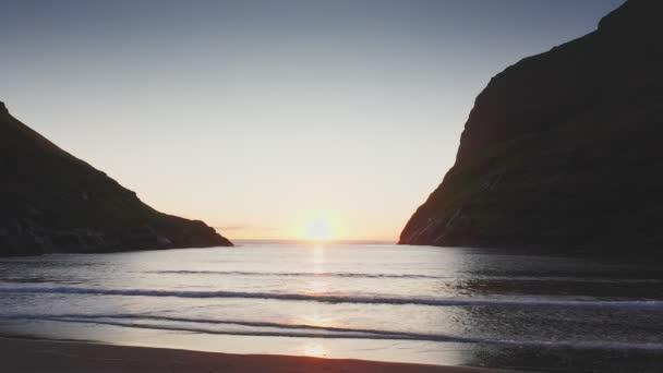 Vista aérea de la puesta de sol en la playa con impresionante reflejo dorado del sol en olas tranquilas. Playa dorada y silueta de montaña en ambos lados.Paisaje y fondos singulares, Islas Feroe — Vídeos de Stock