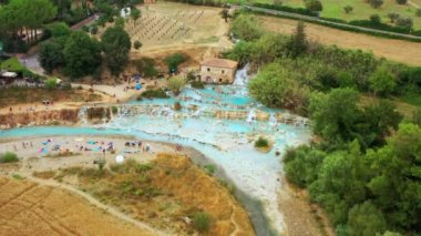 Toskana, İtalya 'daki doğal banyonun havadan görünüşü. Sıcak kristal kaplıca suyu. Saturnia 'da şelaleli ve sıcak kaplıcalı Saturnia termal banyoları, Grosseto, Toskana. Güzel panoramik çekim.