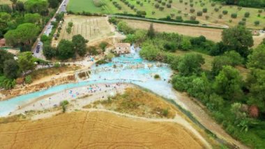 Toskana, İtalya 'daki doğal banyonun havadan görünüşü. Sıcak kristal kaplıca suyu. Saturnia 'da şelaleli ve sıcak kaplıcalı Saturnia termal banyoları, Grosseto, Toskana. Güzel panoramik çekim.