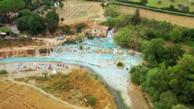 Toskana, İtalya 'daki doğal banyonun havadan görünüşü. Sıcak kristal kaplıca suyu. Saturnia 'da şelaleli ve sıcak kaplıcalı Saturnia termal banyoları, Grosseto, Toskana. Güzel panoramik çekim.