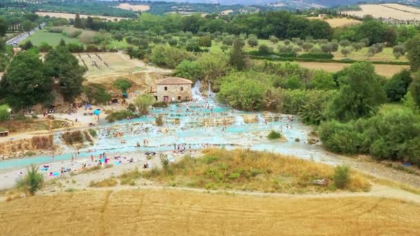 Letecký pohled na přírodní lázně v Toskánsku, Itálie. Horká křišťálová voda z lázní. Přírodní lázně Saturnia s vodopády a horkými prameny v termálních lázních Saturnia, Grosseto, Toskánsko. Krásný panoramatický záběr. — Stock video