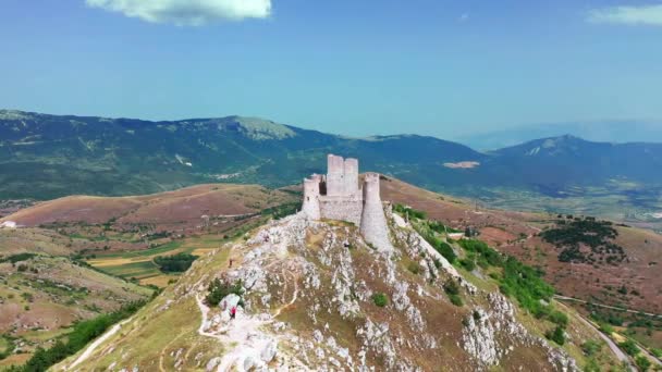 Vue aérienne de l'ancien château sur la colline de montagne, forêt de pins sur la pente de montagne.Rochers blancs et route sale incurvée le long de la montagne. Chaîne de montagnes en arrière-plan avec ciel bleu un jour ensoleillé d'été — Video