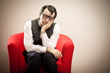 İnek adam kırmızı koltukta uyuya