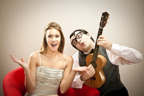 Nerd man vriendje spelen ukulele liefdeslied voor zijn vriendin voor Valentijn — Stockfoto