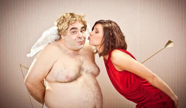 Zaskoczony amorek nieśmiały pocałunek przez miłość pięknej kobiety na Walentynki — Zdjęcie stockowe