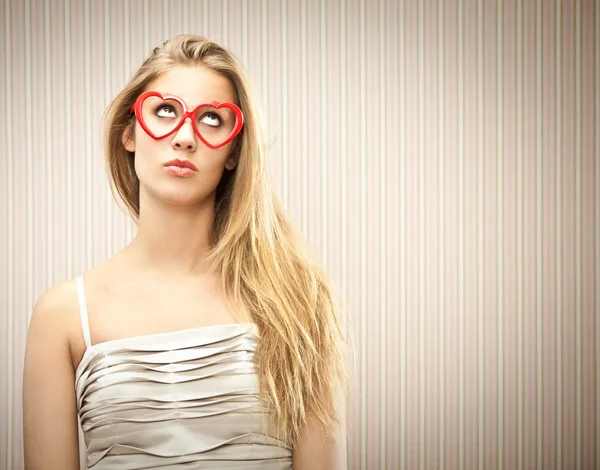 Hermosa chica rubia con gafas de corazón sueñan su amor —  Fotos de Stock