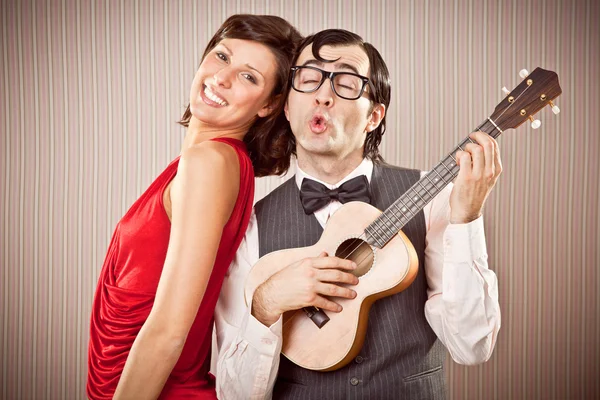 Nerd novio hombre en amor con hermosa mujer jugar un serenata canción con ukelele para San Valentín —  Fotos de Stock