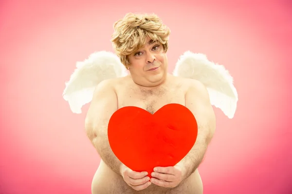 Glücklicher Amor schenkt Liebesherz für Valentinstag — Stockfoto