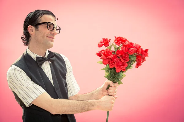 Feliz hombre nerd con gafas dan rosas rojas ramo de flores vista lateral en rosa para el día de San Valentín —  Fotos de Stock
