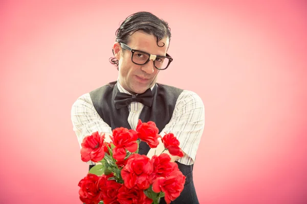 Shy nerd man with glasses give red roses flower bunch on pink for valentine day