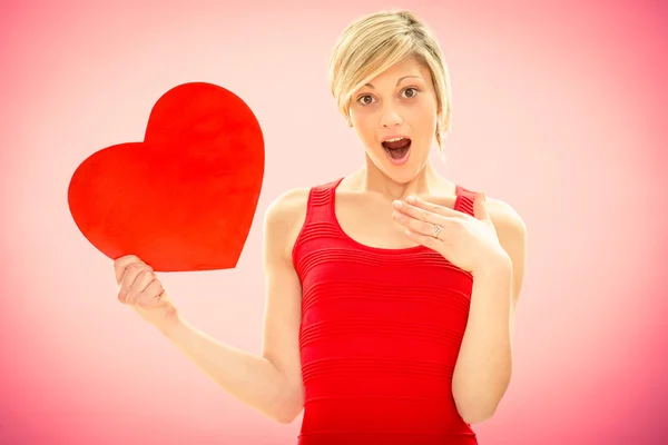 Romantische jonge mooie verrast vrouw met liefde rood hart op roze voor Valentijn — Stockfoto