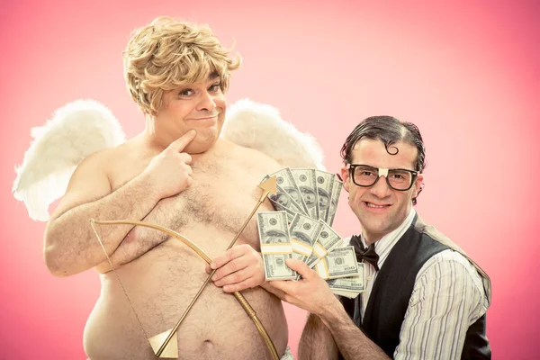 Nerd hombre con gafas trato de amor arco y flecha con dinero de Cupido para el día de San Valentín —  Fotos de Stock