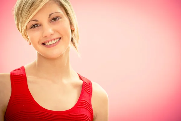 Joven hermosa mujer en vestido rojo sonrisa feliz en rosa — Foto de Stock