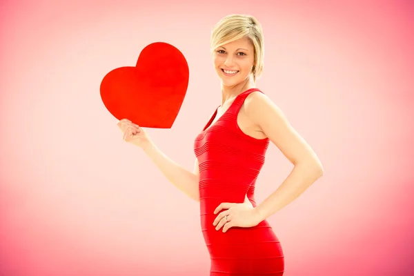 Romantische jonge mooie gelukkige vrouw met liefde rood hart op roze voor Valentijn — Stockfoto
