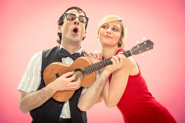 Přítel člověka blbeček hrát ukulele milostnou píseň pro svou přítelkyni na Valentýna — Stock fotografie