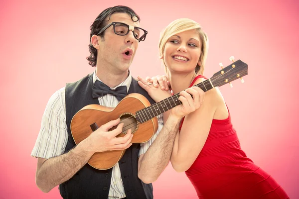 Přítel člověka blbeček hrát ukulele milostnou píseň pro svou přítelkyni na Valentýna — Stock fotografie