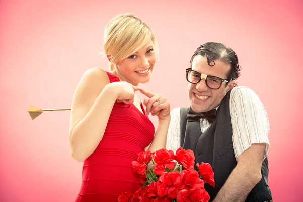 Nerd novio hombre obtener mujer que ama por flecha de cupido y regalo de sus flores de rosa roja para el día de San Valentín —  Fotos de Stock