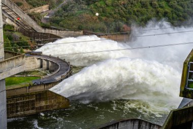 Alqueva, Portekiz - 7 Şubat 2026: Fırtına Marta 'nın ardından Alentejo bölgesinde Alqueva Barajı' nın taşkınlığından su serbest bırakıldı. Şiddetli yağış rezervuar seviyelerini yükselterek, kontrollü boşaltma işlemlerine yol açıyor.