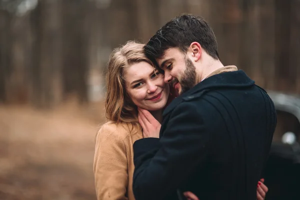 세련 된 사랑 웨딩 커플 키스 하 고 레트로 자동차 근처 소나무 숲에서 포옹 — 스톡 사진