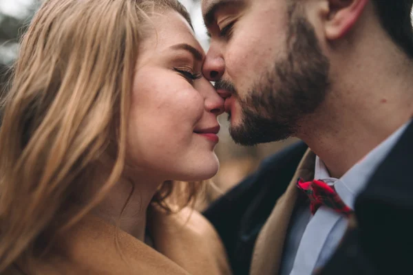 Pasangan pencinta yang bergaya berciuman dan berpelukan di hutan pinus dekat mobil retro — Stok Foto