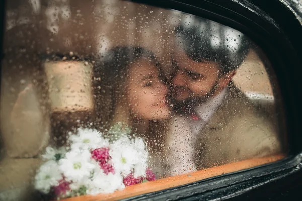 Gorgeous newlywed bride and groom posing in pine forest near retro car in their wedding day — 스톡 사진