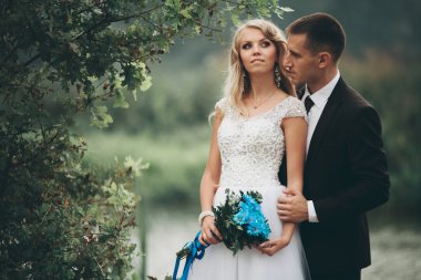 Romantik düğün çift karı güzel göl kenarında poz,