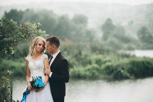 Romantico matrimonio coppia, uomo e moglie, in posa vicino al bellissimo lago — Foto Stock