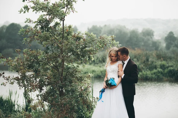 Couple de mariage romantique, homme et femme, posant près du beau lac — Photo