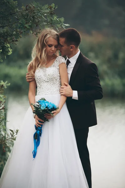 Romantico matrimonio coppia, uomo e moglie, in posa vicino al bellissimo lago — Foto Stock