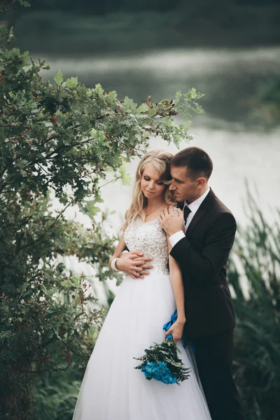 Romantico matrimonio coppia, uomo e moglie, in posa vicino al bellissimo lago — Foto Stock