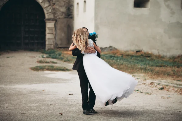 Feliz boda pareja abrazos y besos en el fondo viejo castillo —  Fotos de Stock