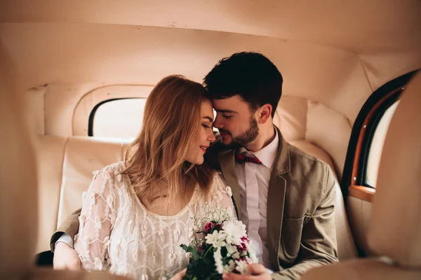 Elegante coppia di nozze amorevole baciare e abbracciare in una pineta vicino auto retrò — Foto Stock