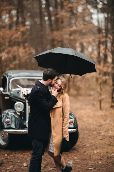 Romantique couple de mariage conte de fées embrasser et embrasser dans la forêt de pins près de voiture rétro . — Photo