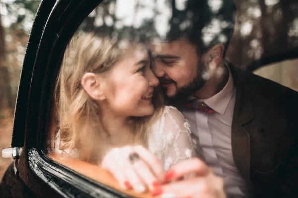 Romantique couple de mariage conte de fées embrasser et embrasser dans la forêt de pins près de voiture rétro . — Photo