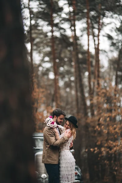 Romantique couple de mariage conte de fées embrasser et embrasser dans la forêt de pins près de voiture rétro . — Photo