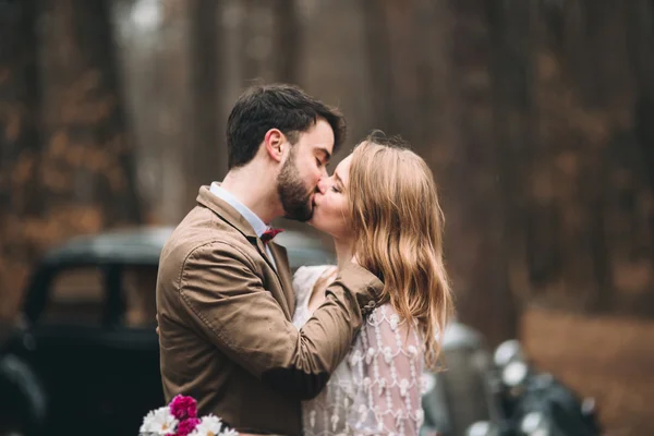 Romantique couple de mariage conte de fées embrasser et embrasser dans la forêt de pins près de voiture rétro . — Photo