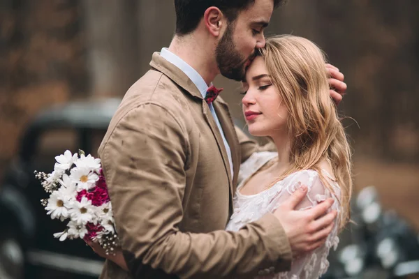 Romantique couple de mariage conte de fées embrasser et embrasser dans la forêt de pins près de voiture rétro . — Photo