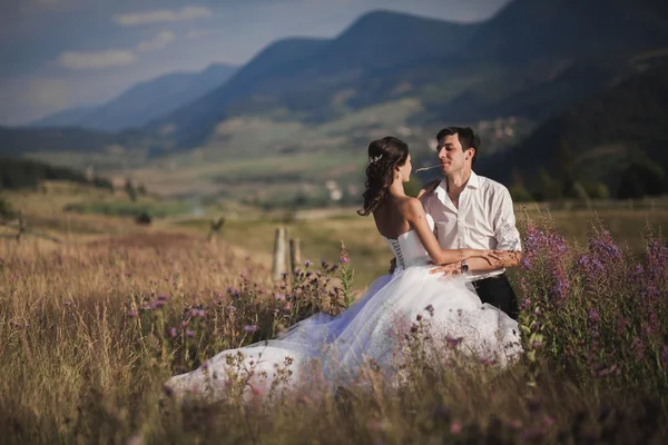 Romantyczna bajka nowożeńcy para całuje i ogarnięcie na tle gór — Zdjęcie stockowe