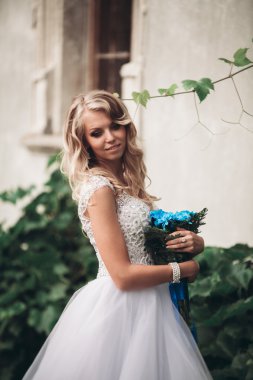 Gelin buketi pozlar arka plan güzel bitkiler üzerinde lüks genç sarışın gelinle