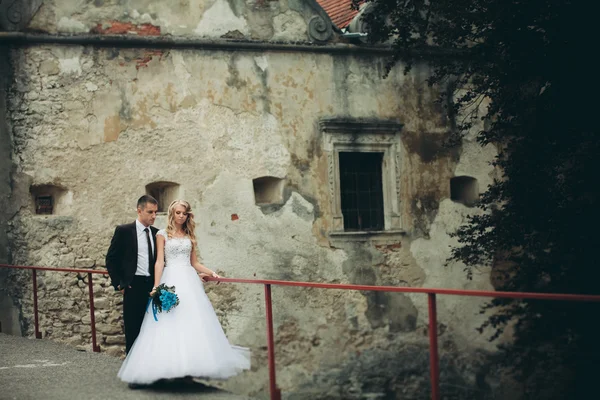 Happy wedding couple hugging and smiling each other on background old castle — Stock Photo, Image